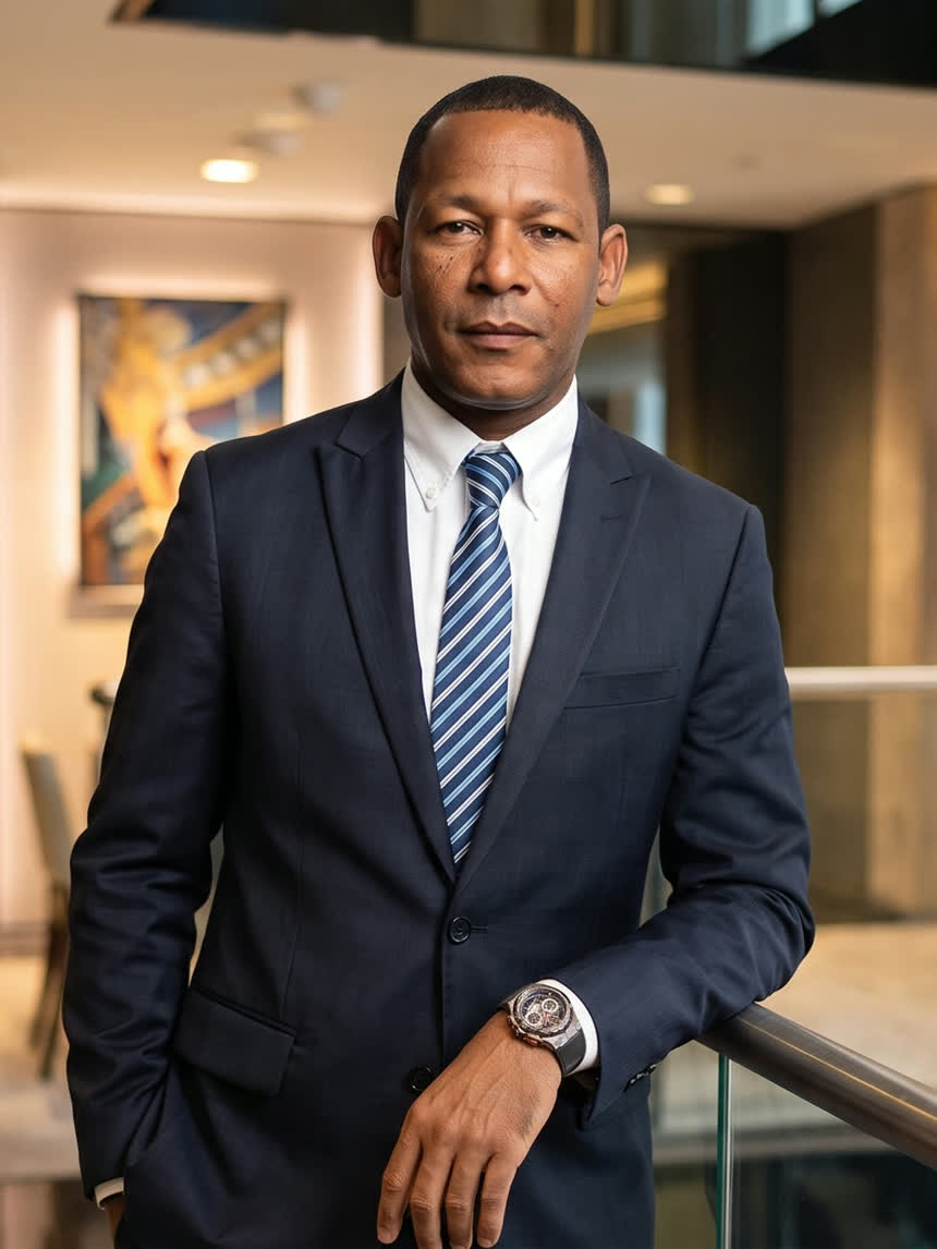 The firm's principal standing in a modern lobby, direct to camera.
